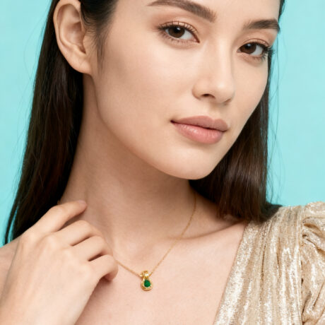 Elegant female model wearing ruby and diamond necklace set in 18K gold by Adenis Jewellery